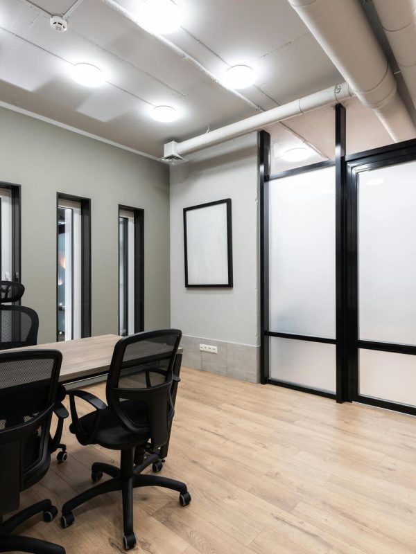 wooden-table-and-black-office-chairs-placed-in-spacious-room-in-new-contemporary-workplace-5ysYotOmy4ZLNgCDk3ZHPg